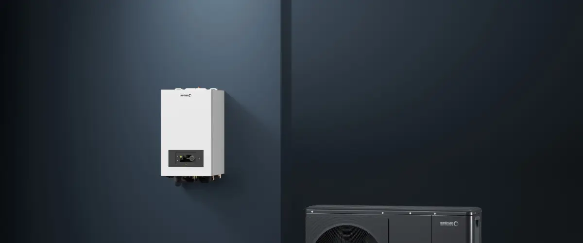 Wandmontierte Gerät auf einer dunklen Wand, daneben ein schwarzes Gerät.