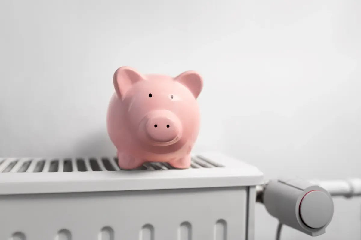 Schweinegeldsparschwein steht auf einem Heizkörper.